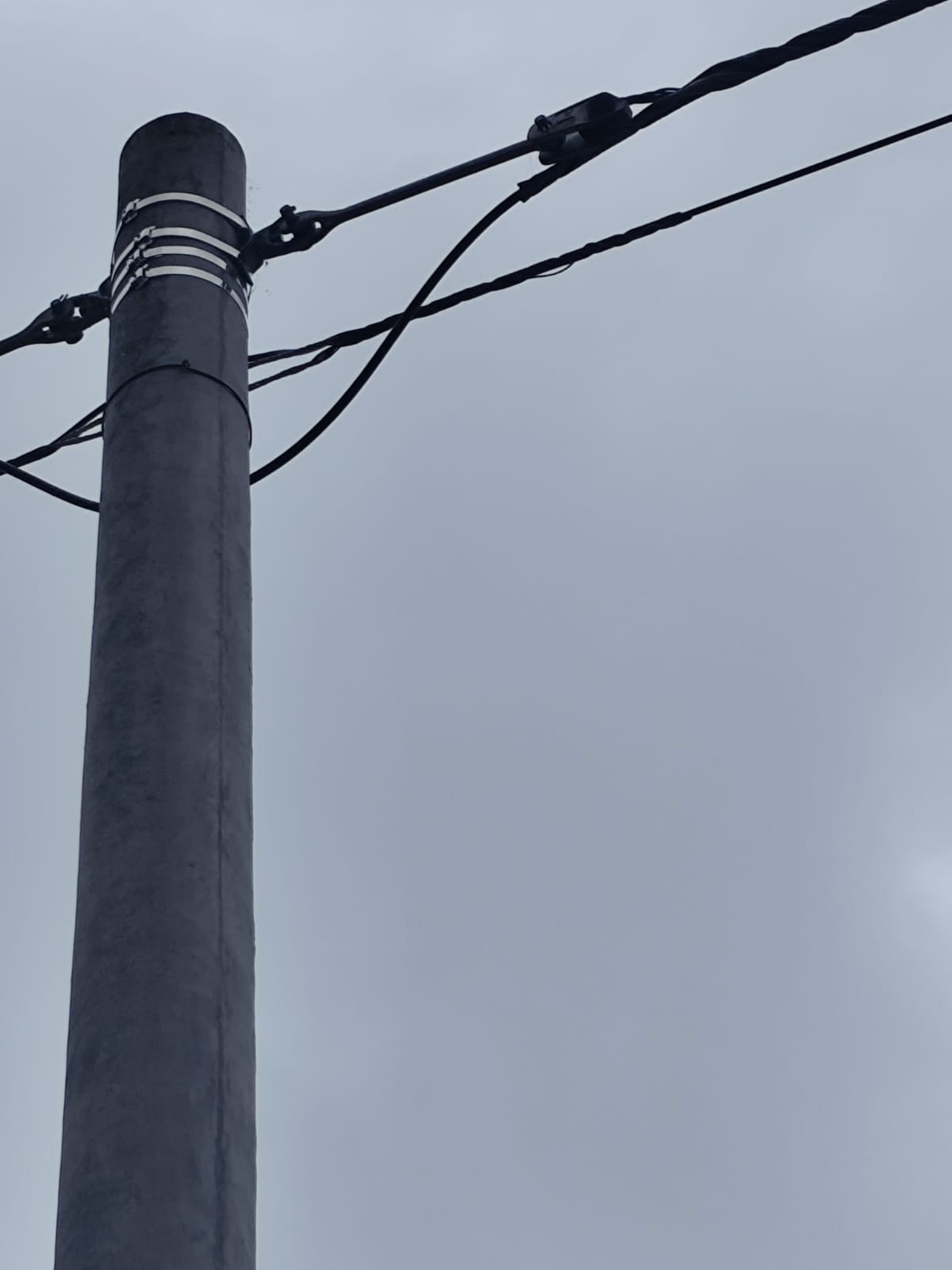 Tecnico instalando gabinete de fibra optica en poste urbano