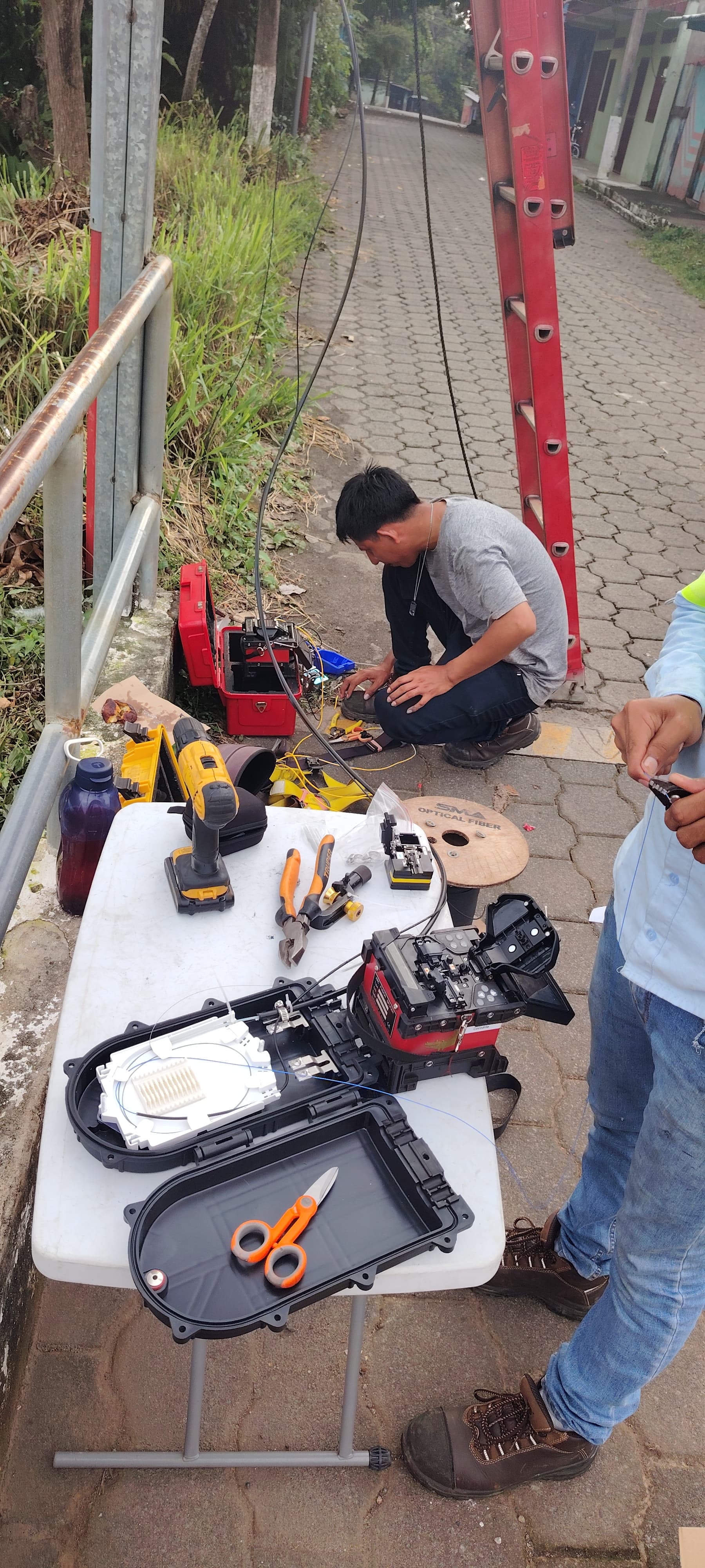 Tecnico y gabinete instalados sobre poste durante proyecto de fibra optica